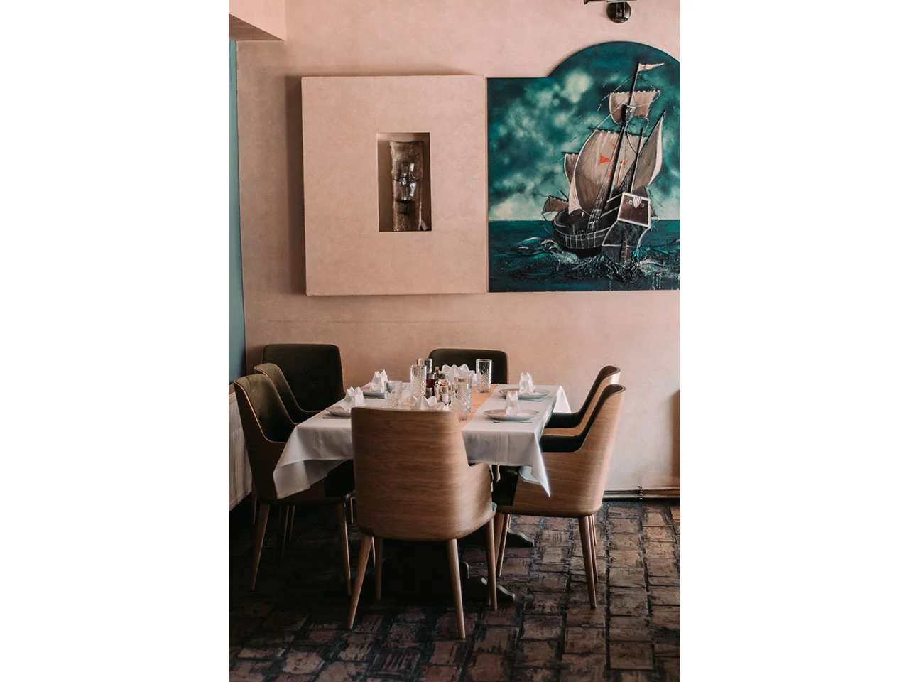 Topao enterijer restorana sa postavljenim stolom